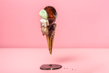 funny creative concept of falling wafer cone with sundae, pistachio and chocolate ice cream scoops...