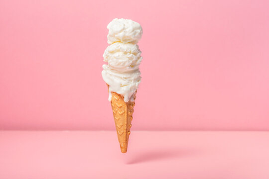 funny creative concept of hovering in air wafer cone with ice cream on pink background