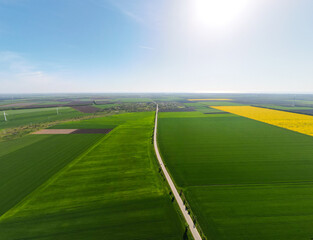 Aerial view of road between green fields, travel concept with highway