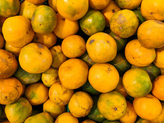 Close up of pile of fresh oranges fruits at stall of supermarket in Asia. Healthy and delicious diet. Flat lay.