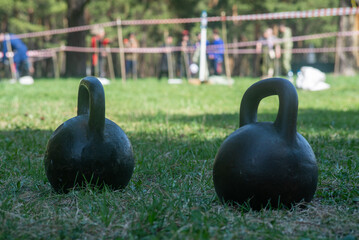 Naklejka na ściany i meble two-pound kettlebells lying on the grass at traditional Cossack competitions