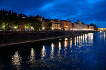 Fototapeta na wymiar Arno river embankment with Ponte Vecchio bridge at night in Italy