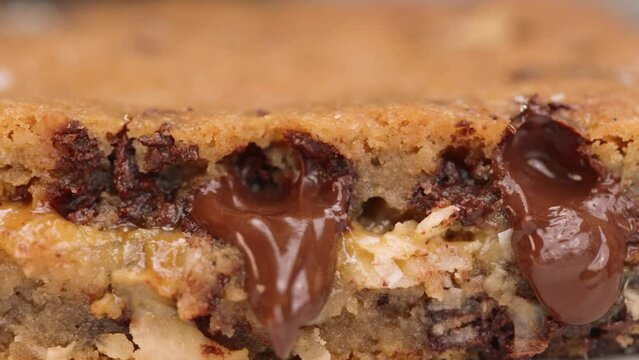 Macro close up of gooey blondie brownie with melted chocolate 4k pan left caramel and coconut