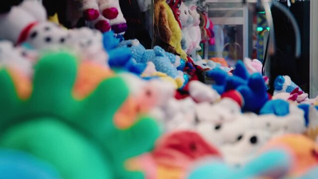 Colorful arcade game toy claw crane machine where people can win toys and other prizes which is located in the shopping mall