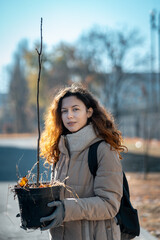 young female planting seedling or tree sapling in park to preserve environment