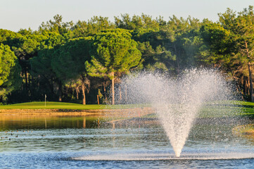 Teich mit Springbrunnen auf einem südländischen Golfplatz