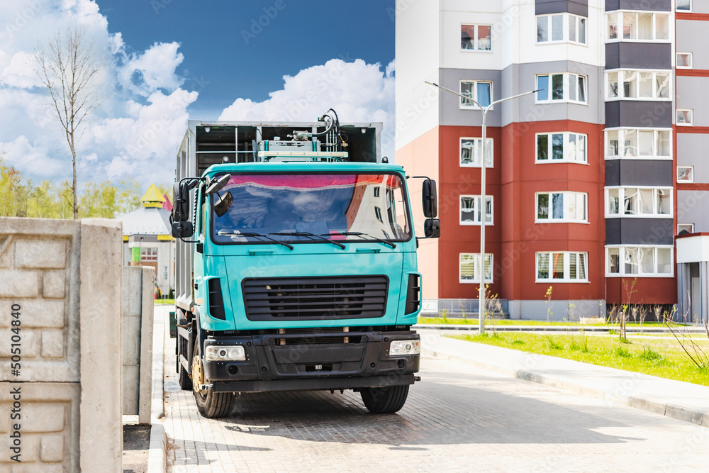 Poster A garbage truck picks up garbage in a residential area. Loading mussar in containers into the car. Separate collection and disposal of garbage. Garbage collection vehicle.