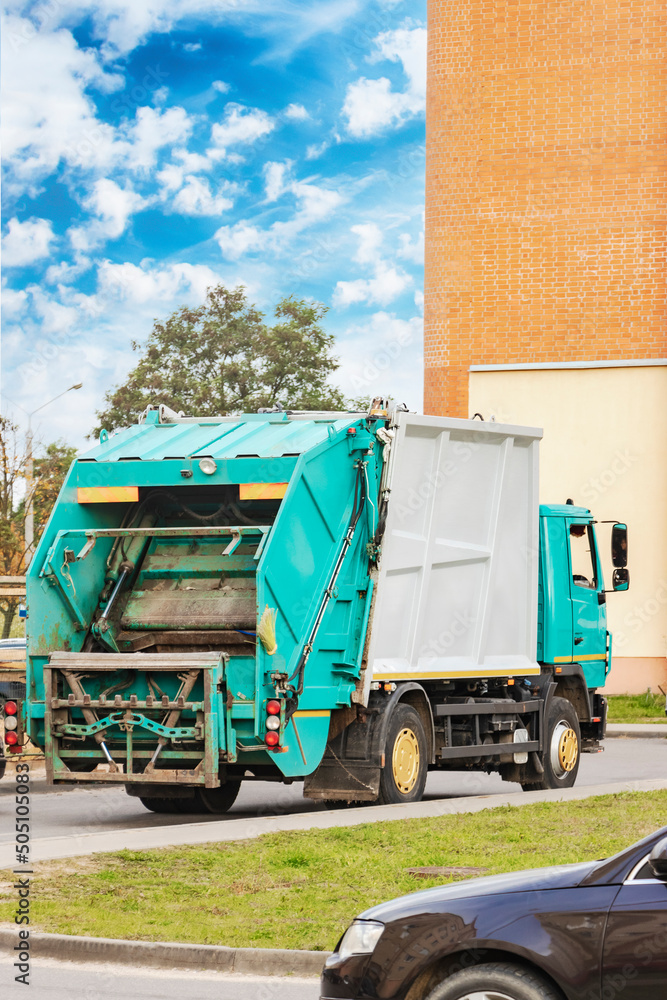 Poster A garbage truck picks up garbage in a residential area. Loading mussar in containers into the car. Separate collection and disposal of garbage. Garbage collection vehicle.