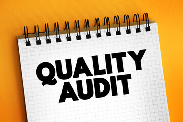 Quality Audit - systematic examination of an organization's quality management system, text concept on notepad