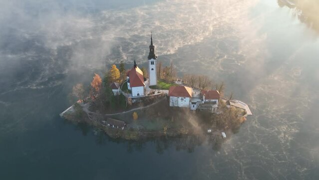 Lake Bled on a beautiful spring morning with mist and low clouds at sunrise. Lake Bled is located in Slovenia, near the Julian Alps. It's an Alpine jewel with a little island in the middle of the lake