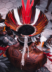 Indigenous man from a Brazilian Amazon tribe wearing colourful feather headdress known as cocar....