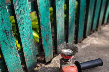  The fence cleaning tool lies on the background of an old wooden fence. Close up