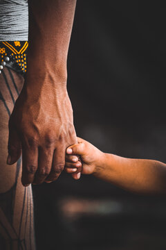 Indian father and son holding hands