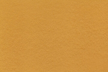 Texture of dark yellow and orange colors paper background, macro. Structure of dense ocher craft...