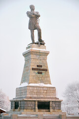 Monument to General Governor-General of Eastern Siberia Nikolai Nikolaevich Muravyov-Amursky in Khabarovsk in the morning at sunrise. There are trees in the snow all around.