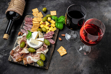 Red wine with charcuterie assortment Antipasto board with sliced meat, ham, salami, cheese, olives...