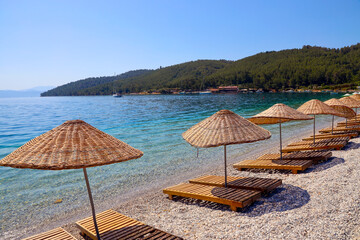wicker umbrella wooden chaise longue by the sea