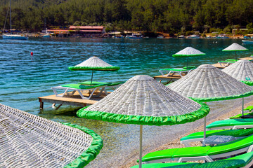 wicker umbrella green chaise longue by the sea
