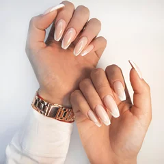 Sanfter Camouflage-Gel-Nagellack auf langen, eckigen Nägeln im French-Design. Hände mit professioneller Maniküre in einem Hemd. Trendige Nagelverlängerung im französischen Design. © OleJohny