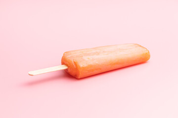 Fruity ice lolly. Sweet popsicle on pink table.