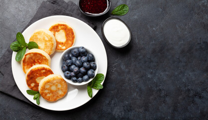Cottage pancakes with jam, sour cream and berries