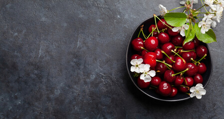 Ripe cherry in bowl with cherry blossom