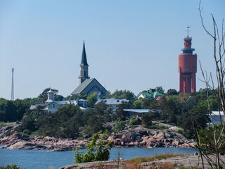 Fototapeta na wymiar Landscape with sea, rocks, trees, church and water tower in Hanko, Finland.