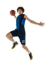Young muscular basketball player in action, motion isolated on white background. Concept of sport,...