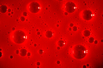 Bubble red background texture. Berry gel to cleanse the skin of the face and body. Spa treatments, skin care. Bath foam, detergent. Slime pink.