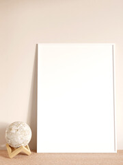 Modern and minimalist vertical white poster or photo frame mockup on the living room wooden table. 3d rendering.