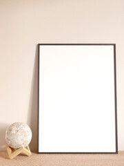 Modern and minimalist vertical black poster or photo frame mockup on the living room wooden table. 3d rendering.