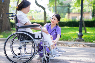 Asian female nurse taking care of a middle-aged female patient in the park