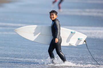 湘南の海でサーフィンをする少年