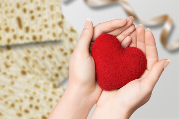Woman's and man hand holds red shape of heart. Traditional of Jewish Holiday
