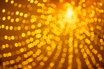 Bokeh background of yellow glow lamps. Garland in bokeh or out of focus. Patern filled with...