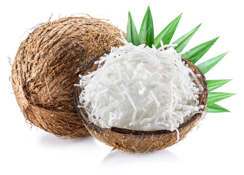 Coconut nuts with coconut flakes and leaves isolated on a white background.