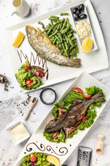 Set of grilled fish dishes, Grilled dorado fish and roasted trout with parmesan. vertical image. top view. place for text