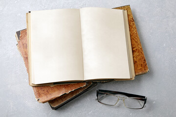 Open vintage book notepad with blank pages and glasses