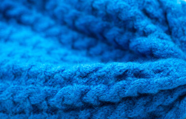 Knitted surface of woolen things as a background. Close-up of soft blue knitted patterns texture. Warm winter clothes. Background textile surface with copy space for text.