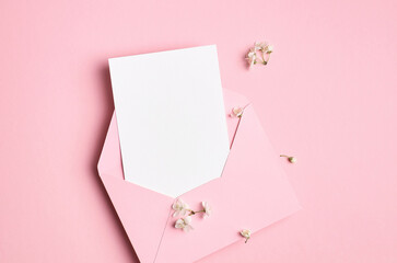 Blank greeting card mockup with envelope and white flowers