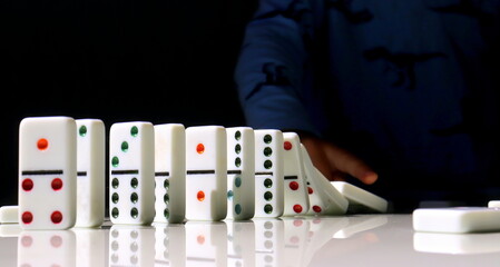 Close-up domino figures and baby's hands in the background selective focus