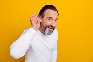 Photo of impressed brunet man hand ear wear white shirt isolated on yellow color background