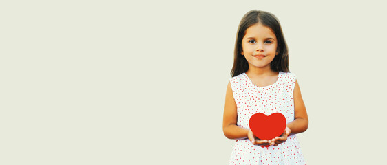 Portrait of happy child holding red paper heart on white background, blank copy space for...