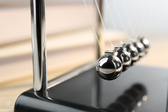 Newton's cradle on table, closeup. Physics law of energy conservation