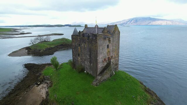 Circling aerial shot of stalker castle on a small tidal island in Loch Laich, Loch Linnescotland United kingdom Europe
