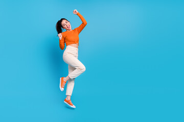 Full length photo of overjoyed ecstatic female raise fists in victory win money prize isolated on blue color background