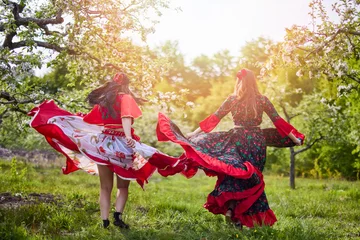 Poster two dancers in traditional gypsy dresses dance in nature on a spring day © czamfir