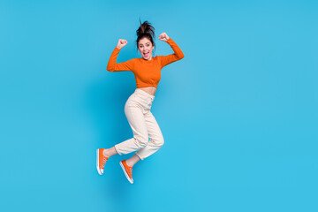 Fototapeta na wymiar Full size image of good mood laughing girl raise fists in success triumph win lottery prize isolated on blue color background