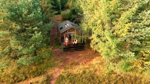 Wooden hut in an autumn forest in the Netherlands, cabin off-grid, wooden cabin fall trees. couple mid-age European man and an Asian woman in the woods during vacation nature trekking fall season