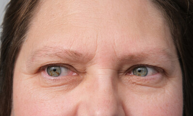 close up part of mature woman 50 years face, girl 20-29 years old, human eye, small wrinkles around...